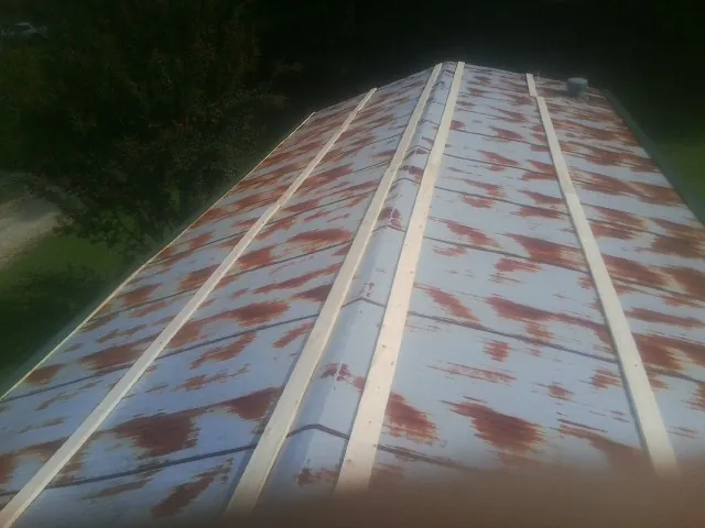 Rusted metal roof panels with new wood purlins before replacement — Storm Damage Roof Repair in Colton by Roofing Brothers